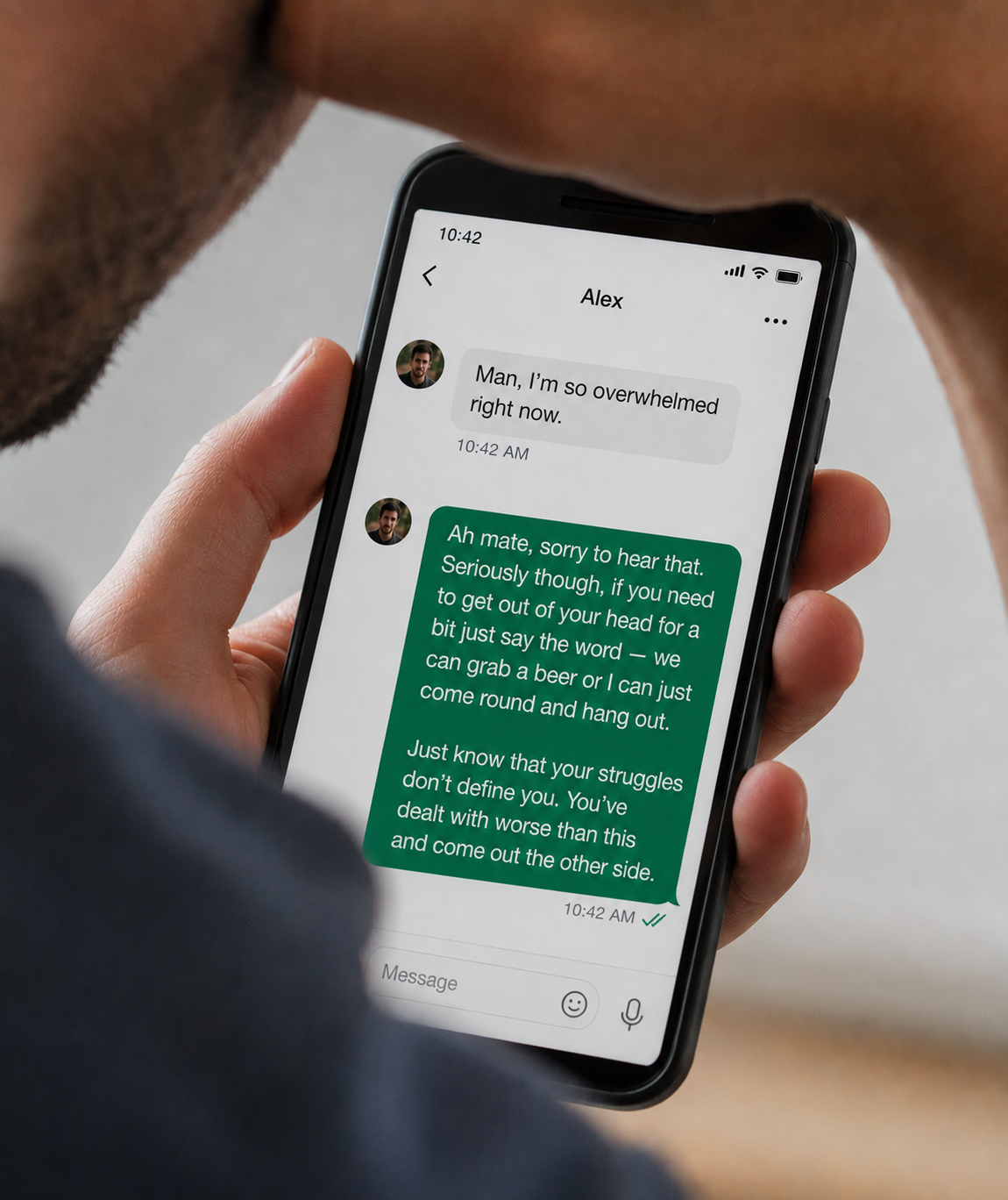 Close-up of the man&rsquo;s phone, showing a message thread with someone called Alex. Alex has written &ldquo;Man, I&rsquo;m so overwhelmed right now&rdquo;. The reply beneath it is a long, polished, slightly poetic message offering to come round, ending &ldquo;you&rsquo;ve dealt with worse than this and come out the other side&rdquo;.